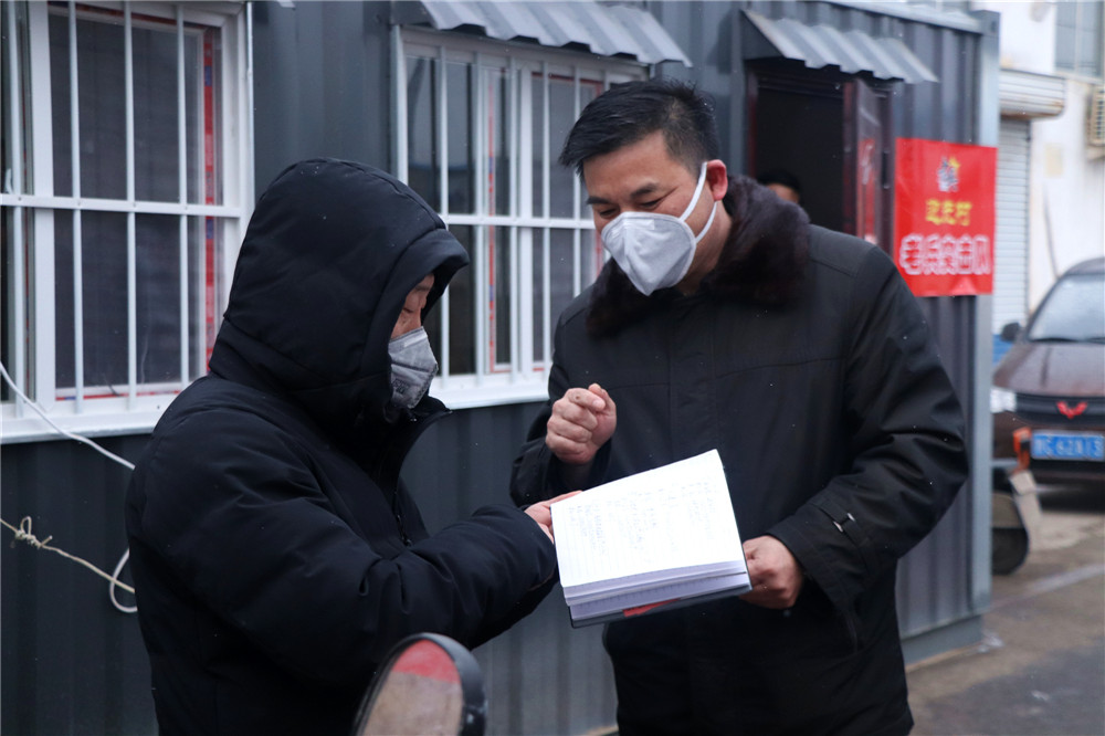 4遇到进村的村民，王宝庆上前详细询问外出事宜，为其进行登记。.JPG