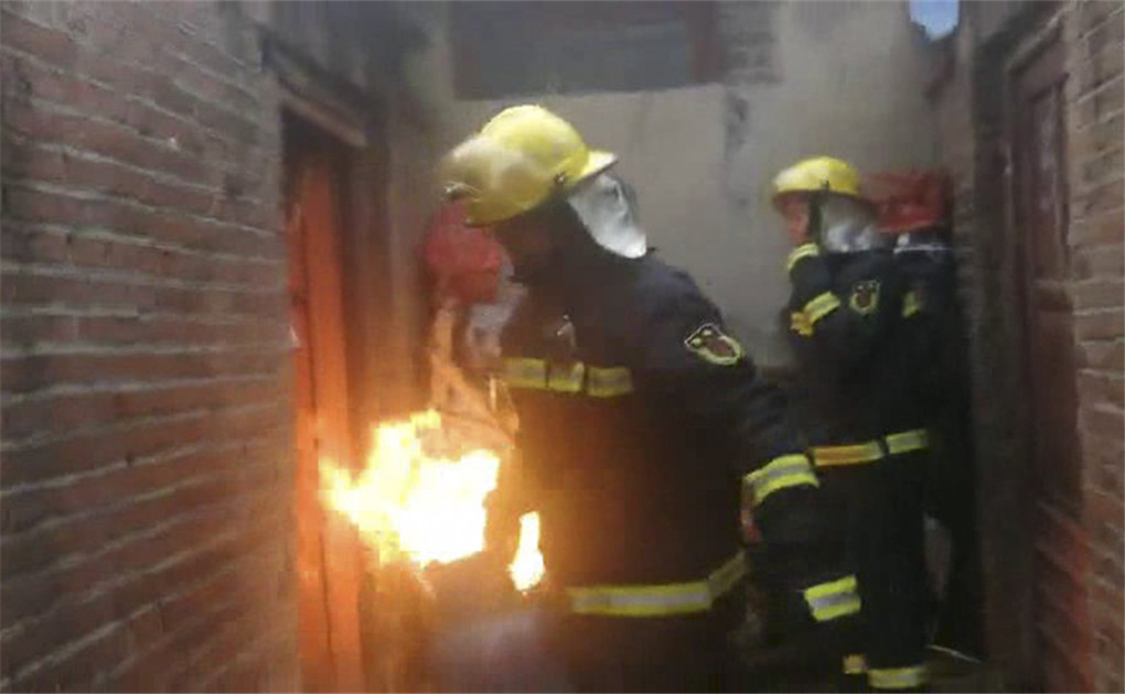 消防员将着火的煤气罐拎出村民家.jpg